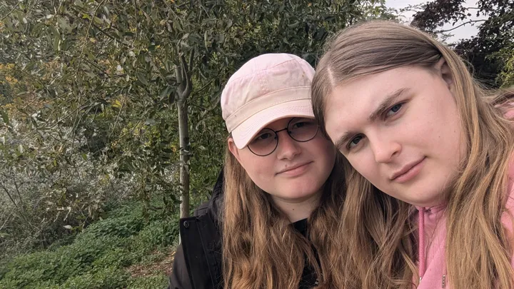 A selfie of Alice and Xena in front of a tree